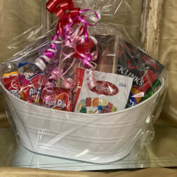 Gift basket with assorted candy and a pink ribbon