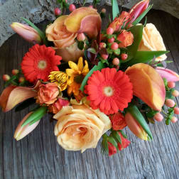 Mixed bouquet with peach roses, red gerberas, calla lilies, and pink buds