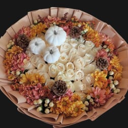 Bouquet of white roses with pink and yellow flowers and small white pumpkins