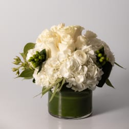 White rose and hydrangea bouquet in a green glass vase
