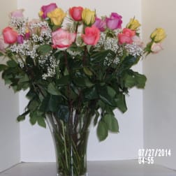 Bouquet of pink and yellow roses in a clear glass vase