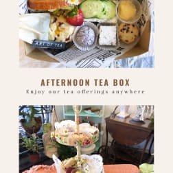 Afternoon tea box and tiered stand with assorted sandwiches, pastries, fruit, and small flower garnishes.