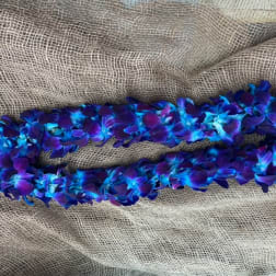 Blue and purple flower lei on burlap fabric