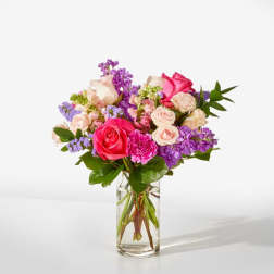 Bouquet of pink and purple flowers in a clear glass vase
