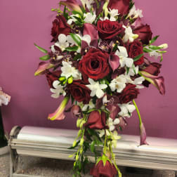 Cascade bouquet of red roses, white orchids, and burgundy calla lilies