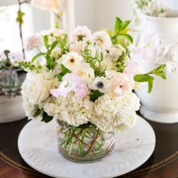 White and blush floral arrangement in a clear glass vase