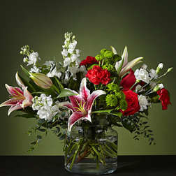 Bouquet of red roses, pink lilies, and white flowers in a glass vase