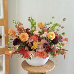 Colorful mixed flower arrangement in a white bowl vase