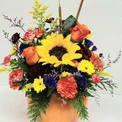 Pumpkin-shaped vase with sunflowers, roses, and carnations