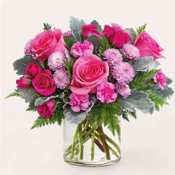 Pink roses and small pink flowers in a clear glass vase