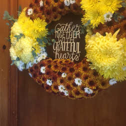 Chrysanthemum wreath with a "Gather Together with Grateful Hearts" sign