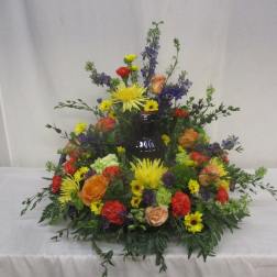 Colorful floral arrangement around a dark vase centerpiece