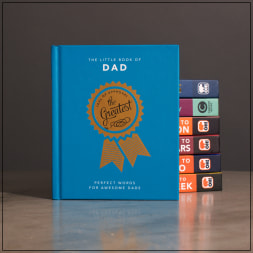 Blue gift book titled "The Little Book of Dad" with stacked books behind it