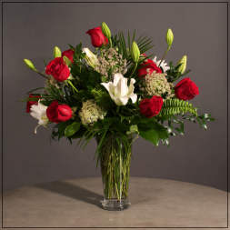Red roses and white lilies in a clear glass vase