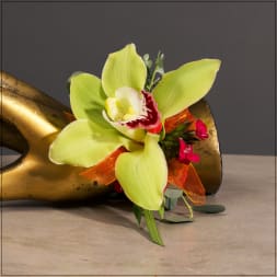 Lime green orchid bloom with orange ribbon on a gold sculpture