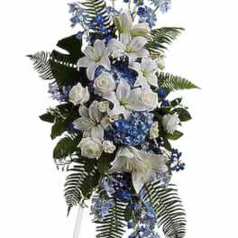 Tall white and blue floral standing spray on an easel