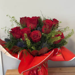 Bouquet of red roses wrapped in red paper
