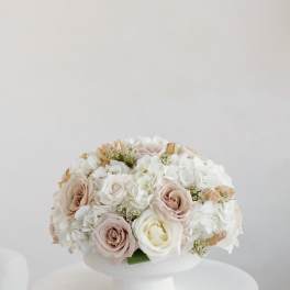 Blush and white roses with white hydrangeas in a white pedestal vase