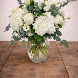 White hydrangea and rose bouquet in a clear glass vase