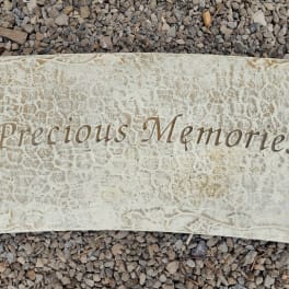 Stone memorial plaque engraved with "Precious Memories"