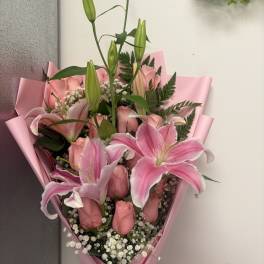 Pink lily and rose bouquet wrapped in pink paper