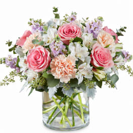 Pink roses and peach carnations in a clear glass vase