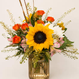 Sunflower and mixed rose bouquet in a ribbed glass vase