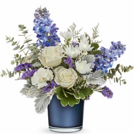 White roses and purple-blue flowers in a blue vase