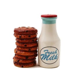 Mini milk bottle and stack of cookies on a white background