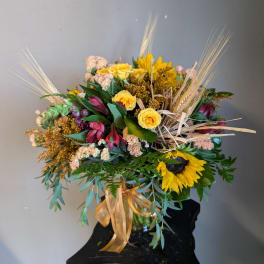 Mixed bouquet with yellow roses and a sunflower in a glass vase