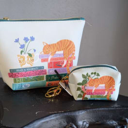 Two floral-print zip pouches with an orange cat and books