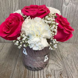Pink roses and white carnations in a decorated vase with small ghost accents