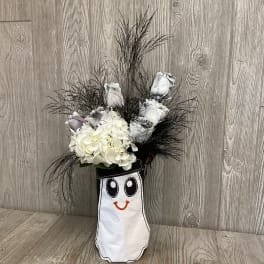 White roses and hydrangeas in a smiling ghost-shaped vase