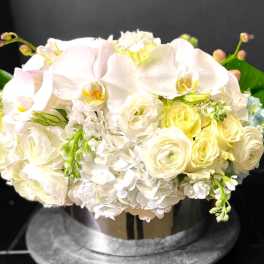 White and pale yellow bouquet with orchids and roses in a vase
