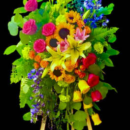 Colorful standing floral arrangement on an easel with sunflowers, roses, and lilies