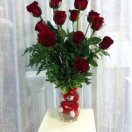 Tall bouquet of red roses in a clear glass vase