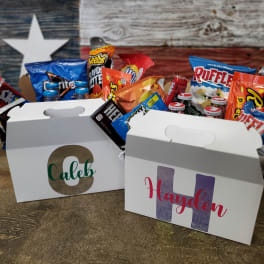 Two personalized snack boxes filled with assorted chips and candy