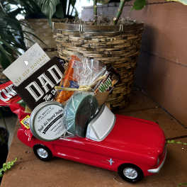 Gift basket in a red toy car with snacks and grooming items