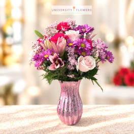 Pink and purple mixed bouquet in a pink glass vase