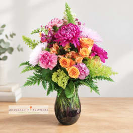 Colorful mixed bouquet in a dark glass vase