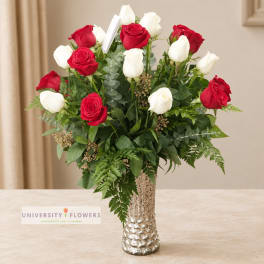 Red and white roses arranged in a tall silver vase