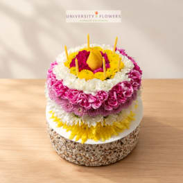 Round floral cake with candles and a pear-shaped topper