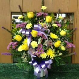 Large mixed bouquet with yellow roses and purple flowers in a vase