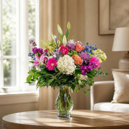 Mixed bouquet of colorful flowers in a clear glass vase