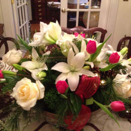 White lilies and pink tulips arranged in a low centerpiece with roses