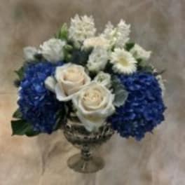 Blue and white flower arrangement in a silver vase