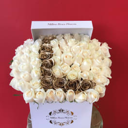 Boxed arrangement of cream and gold roses against a red background