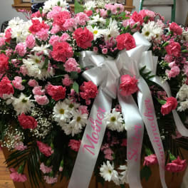 Large pink and white funeral spray with a satin ribbon