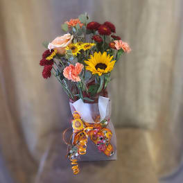 Mixed bouquet with sunflowers, roses, and carnations wrapped in paper