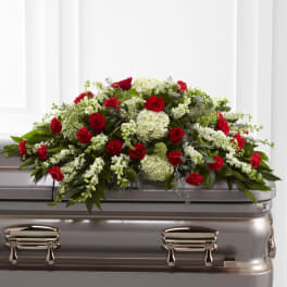 Red and white floral spray on a silver casket